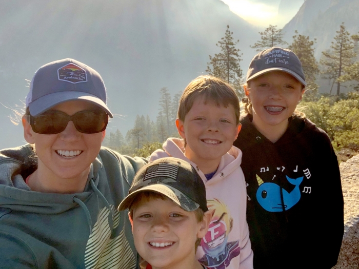 mom smiling with 3 kids