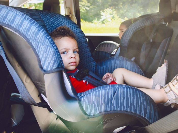 child in back seat of car in car seats