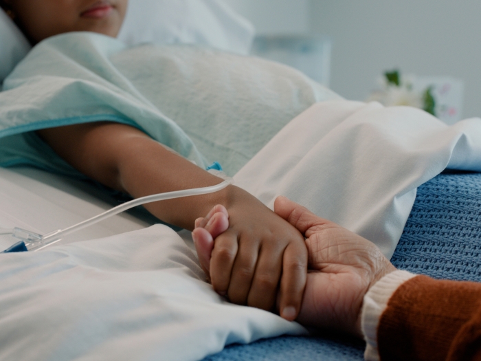 hand holding in bed child hopsital