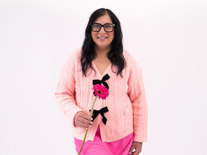 woman wearing all pink and holding pink flower