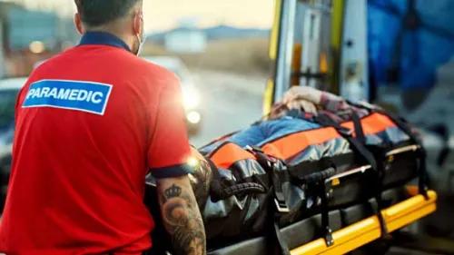 Paramedic lifting person onto ambulance