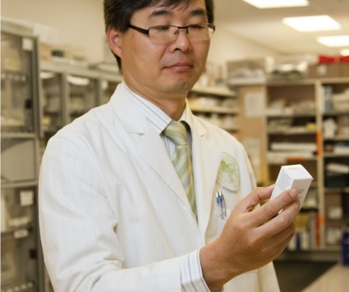 Dr. reading a box of pills