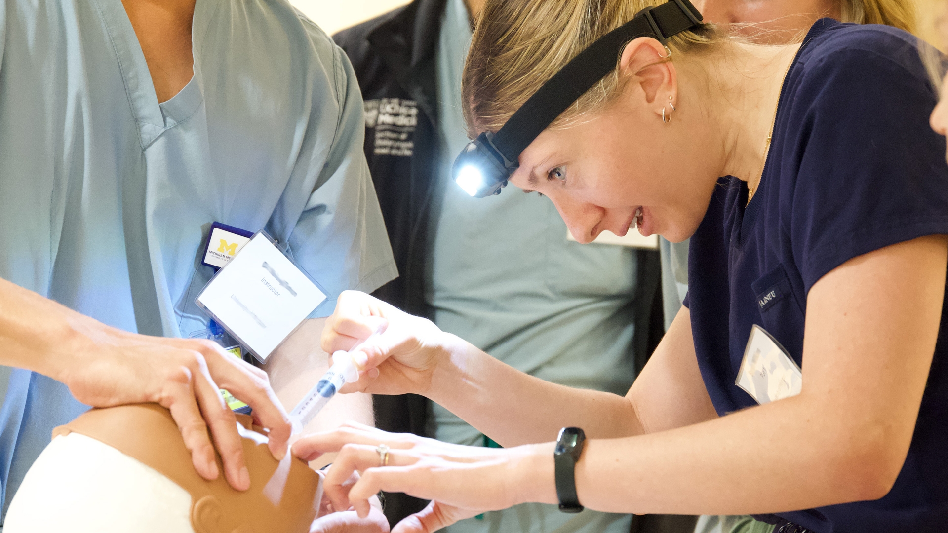 Medical trainee performing a procedure on a medical mannequin