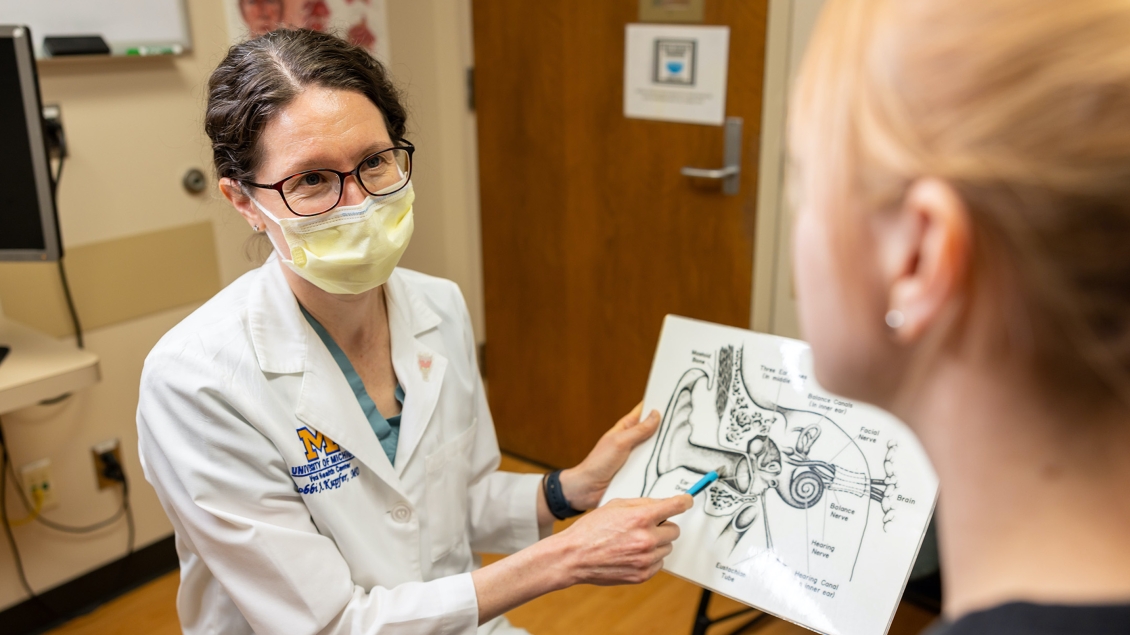 doctor sits while explaining diagram to patient 