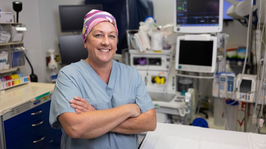 a person in scrubs and a pink and white head wrap