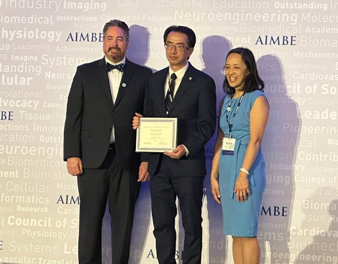 Professor Jun Li holds certificate at event with colleagues