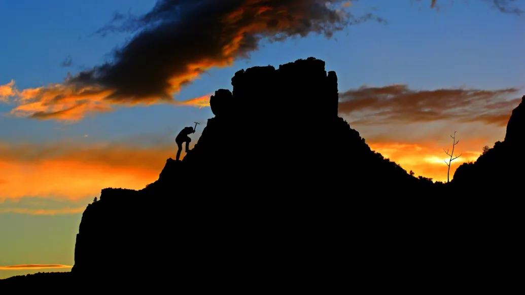 climber on a rocky outcrop at dusk