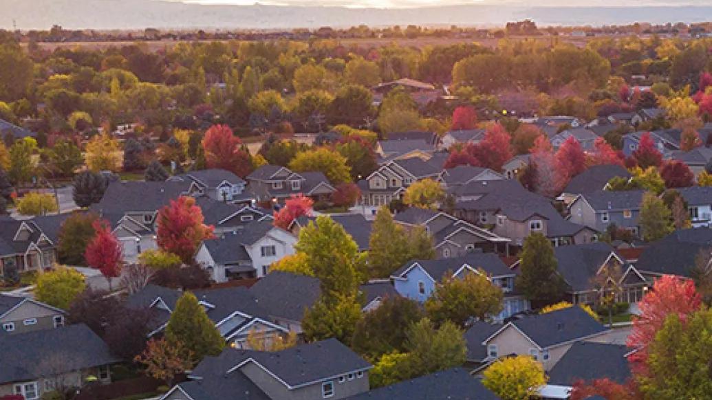 Aerial shot of a suburban neighborhood with the sun in the background