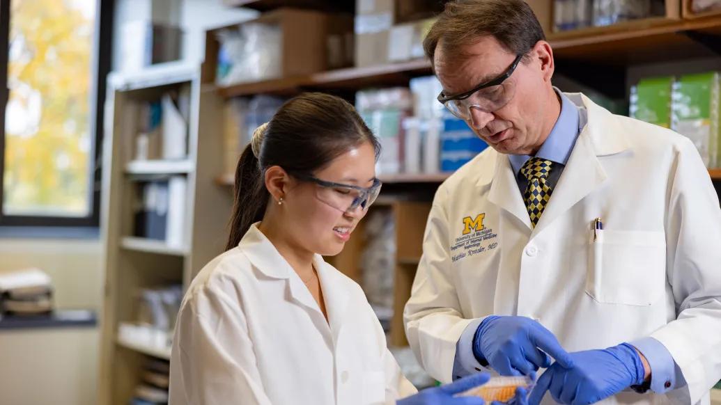 Dr. Kretzler and lab member looking at a sample in the lab
