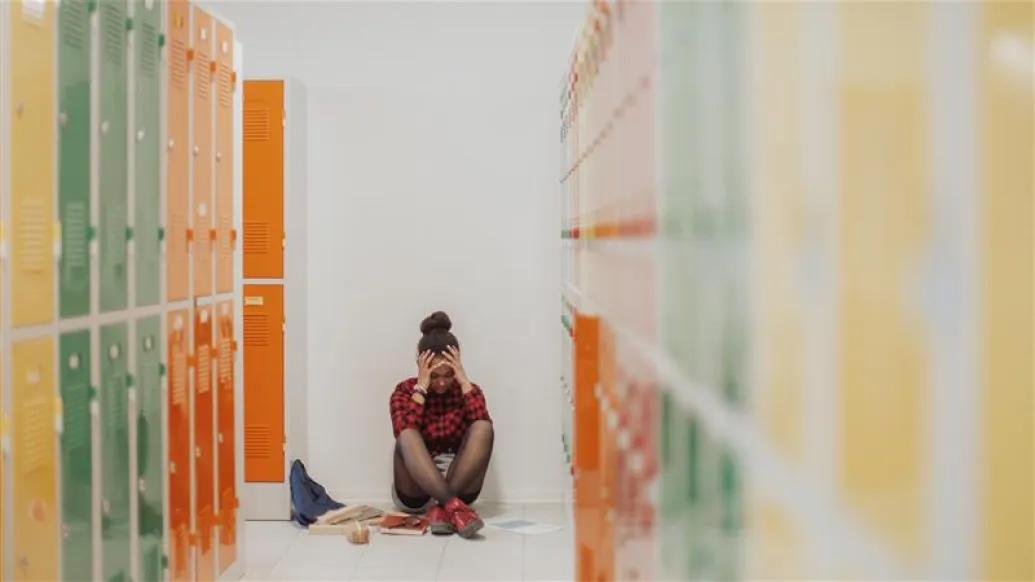 yellow orange green lockers girl upset sitting