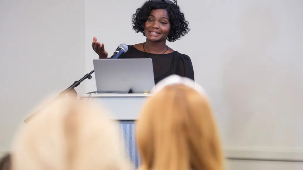 U-M patient, author, coach, and diabetes advocate Safiyah Basir speaks at a CDI Community Seminar, presenting to attendees from behind a podium and microphone.
