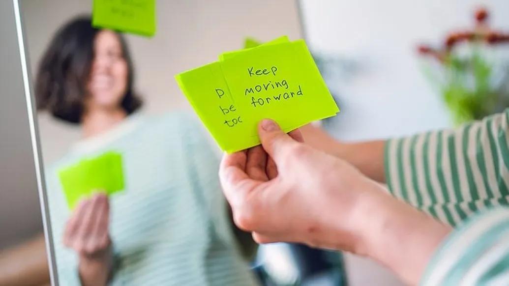A women standing in front of the mirror with Post-its