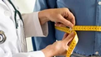 a doctor measuring the waist of a patient