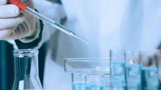 Person using a pipette in a lab
