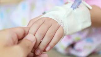 Parent holding child's hand with IV