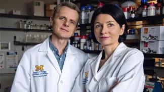 two researchers posing white coats looking at camera