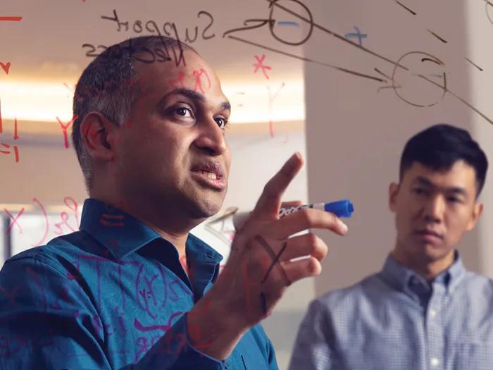 Dr. Vydiswaran explains his research on a dry erase board