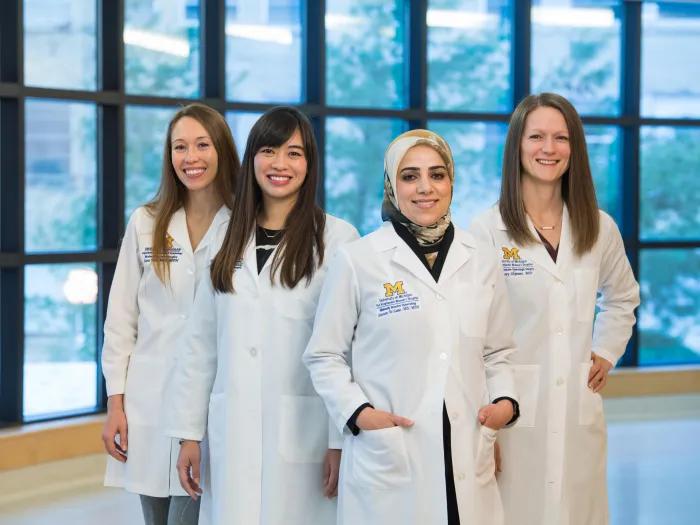  Doctors smile for camera in window hallway