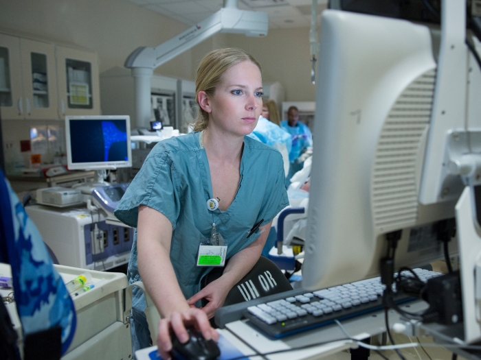 doctor standing aver computer in operating room 