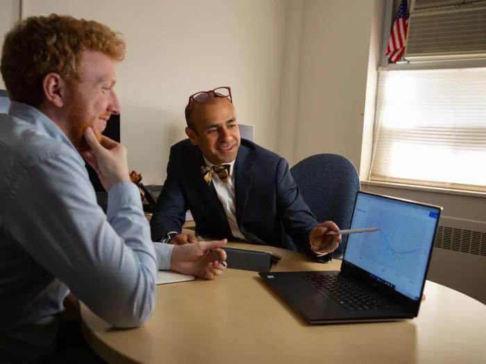 Dr. Uppal meeting with a learner and looking at a laptop together