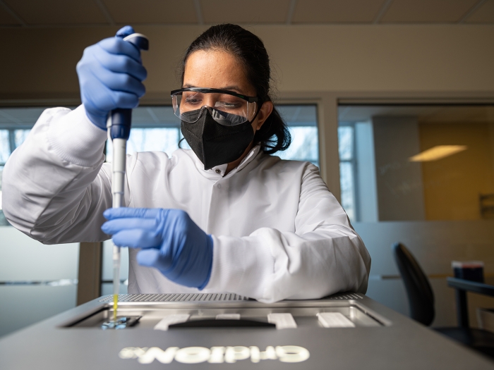 woman in lab holding advanced genomics technology