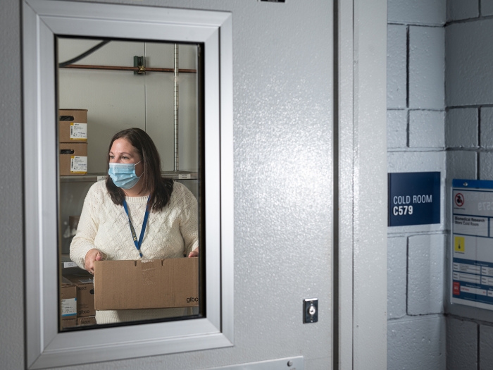 woman in cold room carrying box