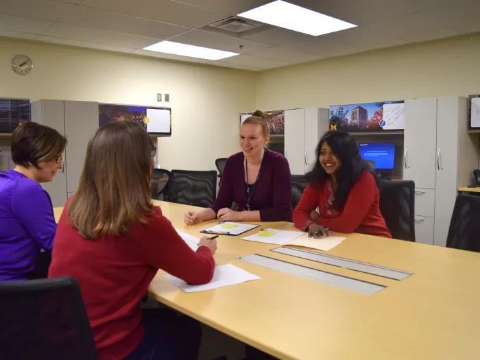 Photo of four female study coordinators sitting at a table at UH South