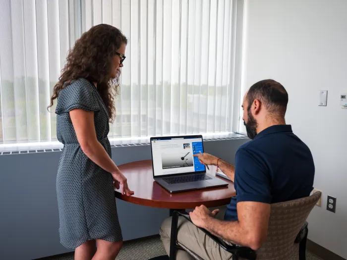 Photo of a man and woman in front of a computer