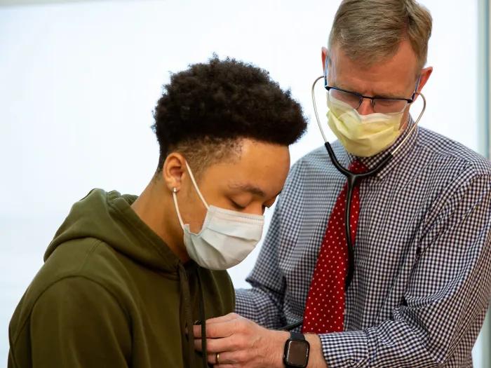 doctor checking heart on patient