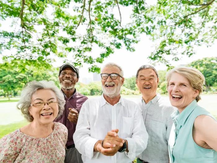 Three older gentlemen and two older ladies smiling in a group outside
