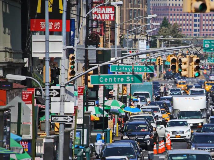 photo of a busy street in chinatown with fast food and paint shops