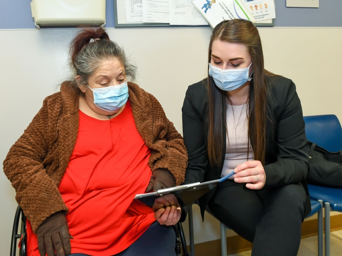 woman sitting looking at paperwork wearing blue masks