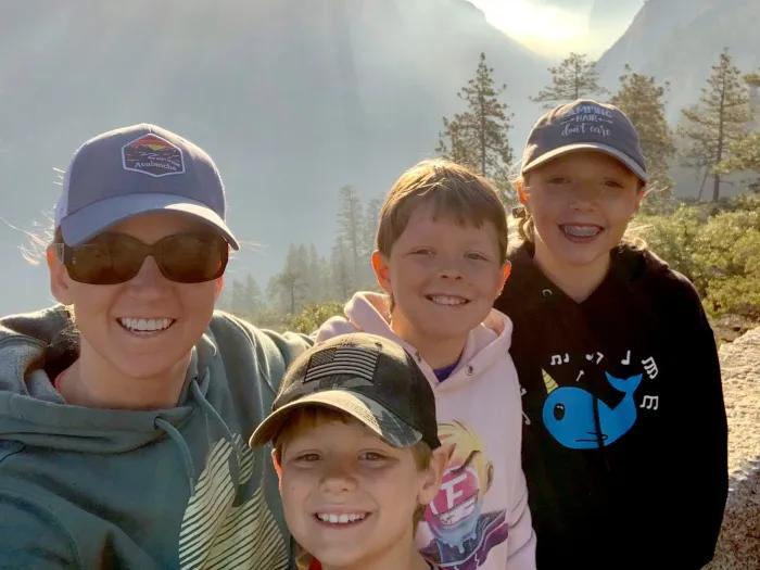 mom smiling with 3 kids