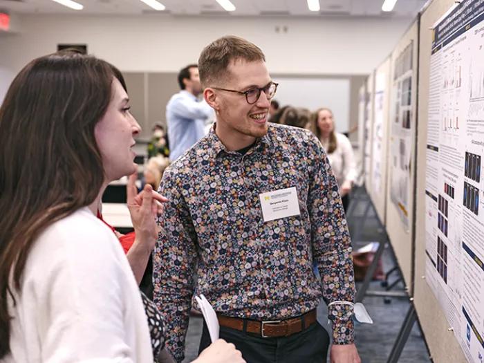 Young woman and young man looking at a scientific poster