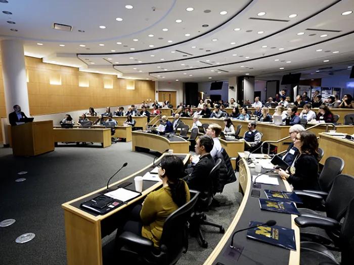 Speaker addressing a crowded auditorium