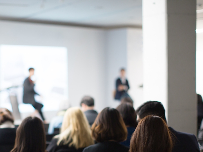 a crowd of people facing two presenters 