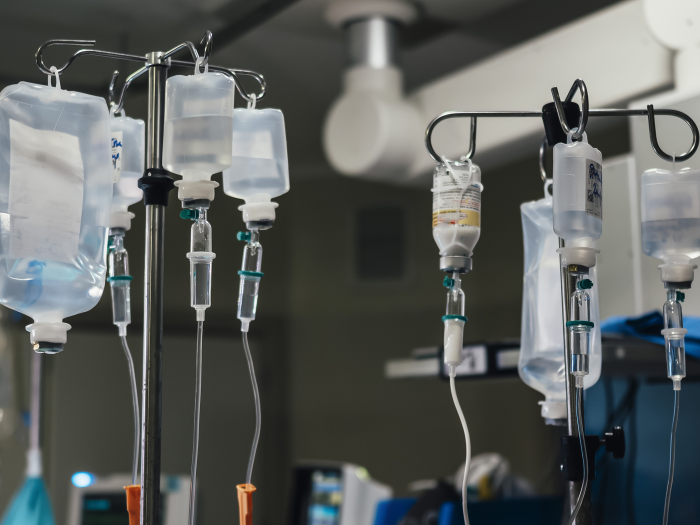 Close-up of multiple IV fluid bags in an operating room