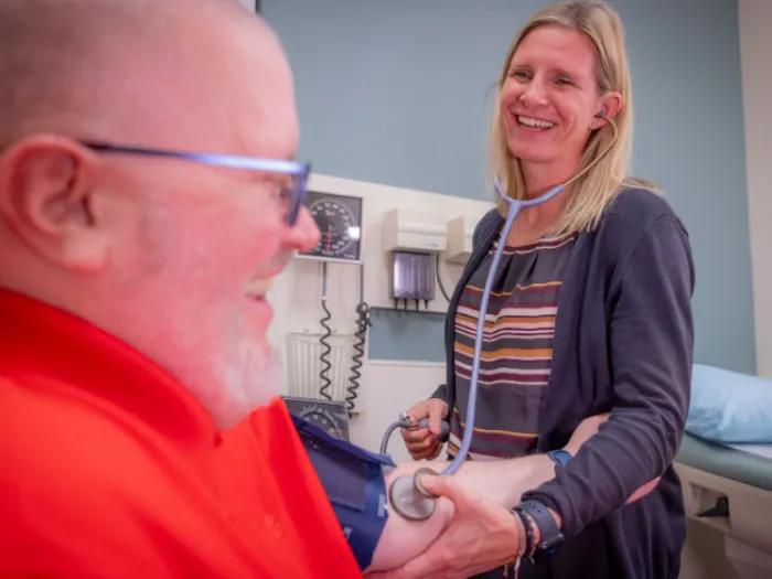 Samantha Fink, administrative manager at U-M Health Cardiovascular Medicine at Domino's Farms, takes a person's blood pressure.