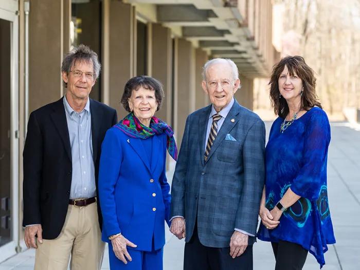 Group of four people posing for a photo outside