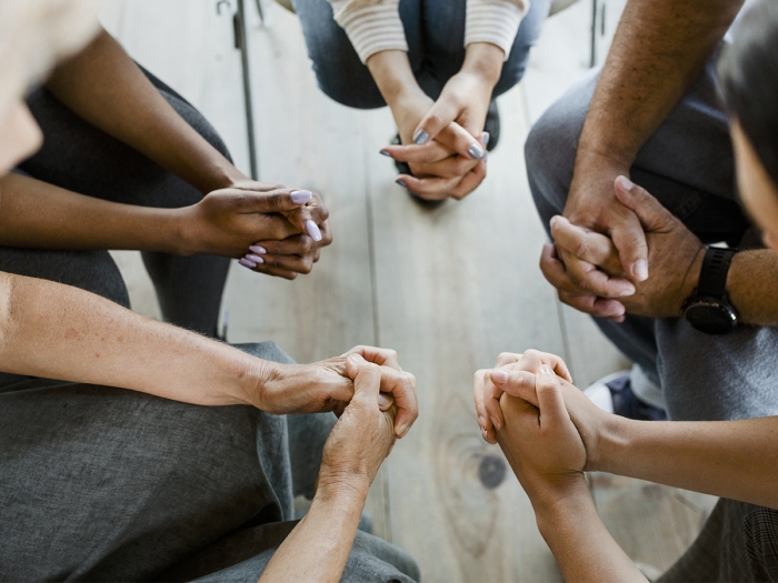 close-up of hands folded in a group