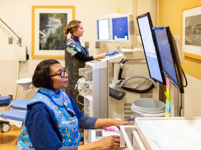 Female provider looks at computer screen at hospital