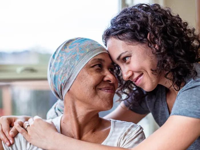 two women hugging with cap over hair