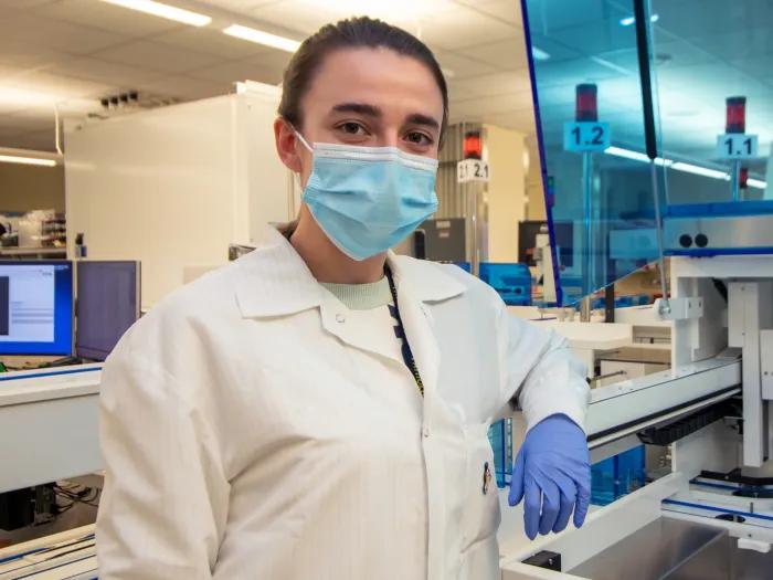 woman posing for photo in research lab wearing PPE