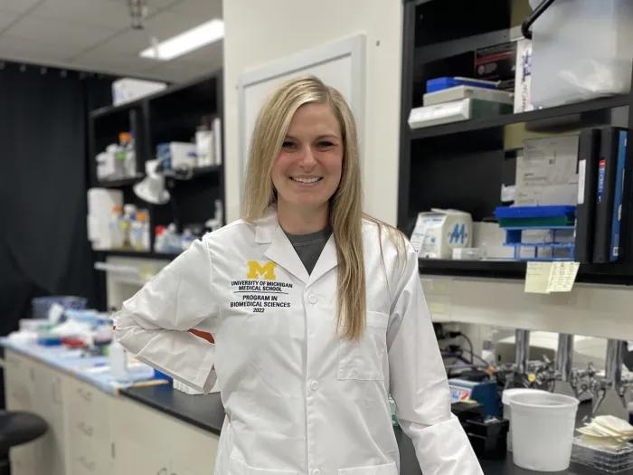 Nicole wearing a lab coat standing in a laboratory