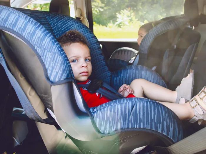 child in back seat of car in car seats