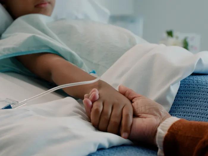 hand holding in bed child hopsital