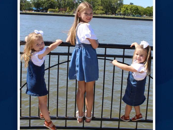 three girls posing in front of water