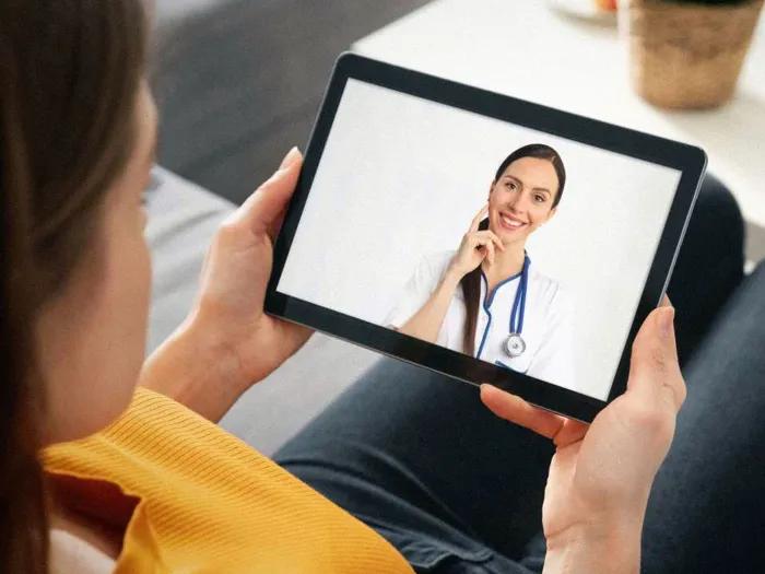 person looking at ipad with provider on screen smiling