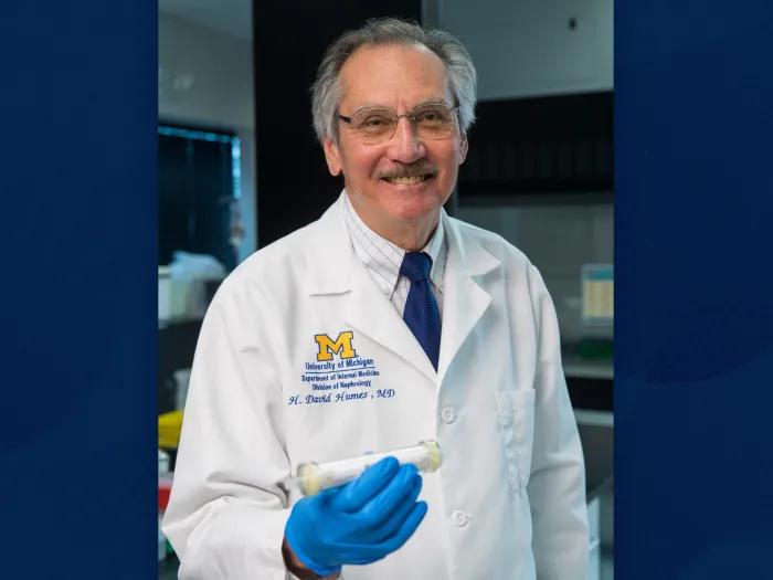 man showing device in his hand smiling with blue gloves on