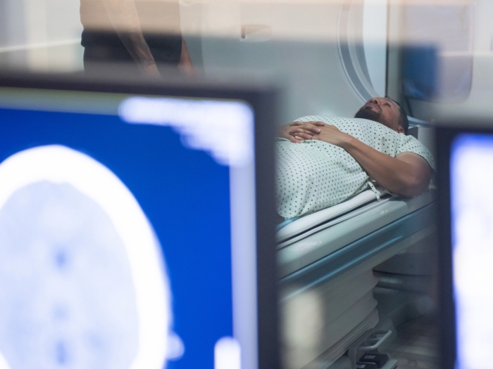 photo of patient in MRI machine with computers closer up seeing scan